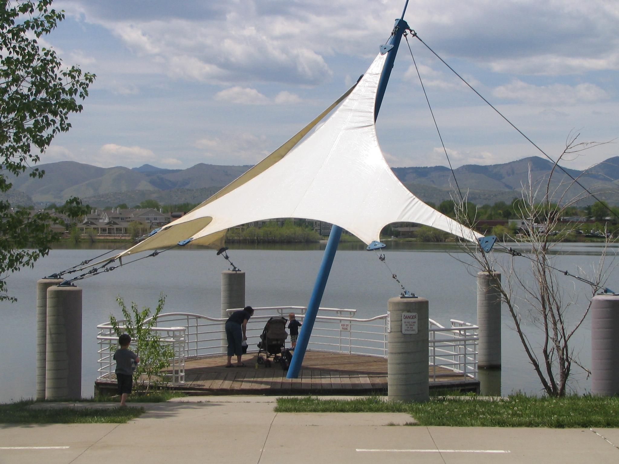 White shade sail beside a waterfront